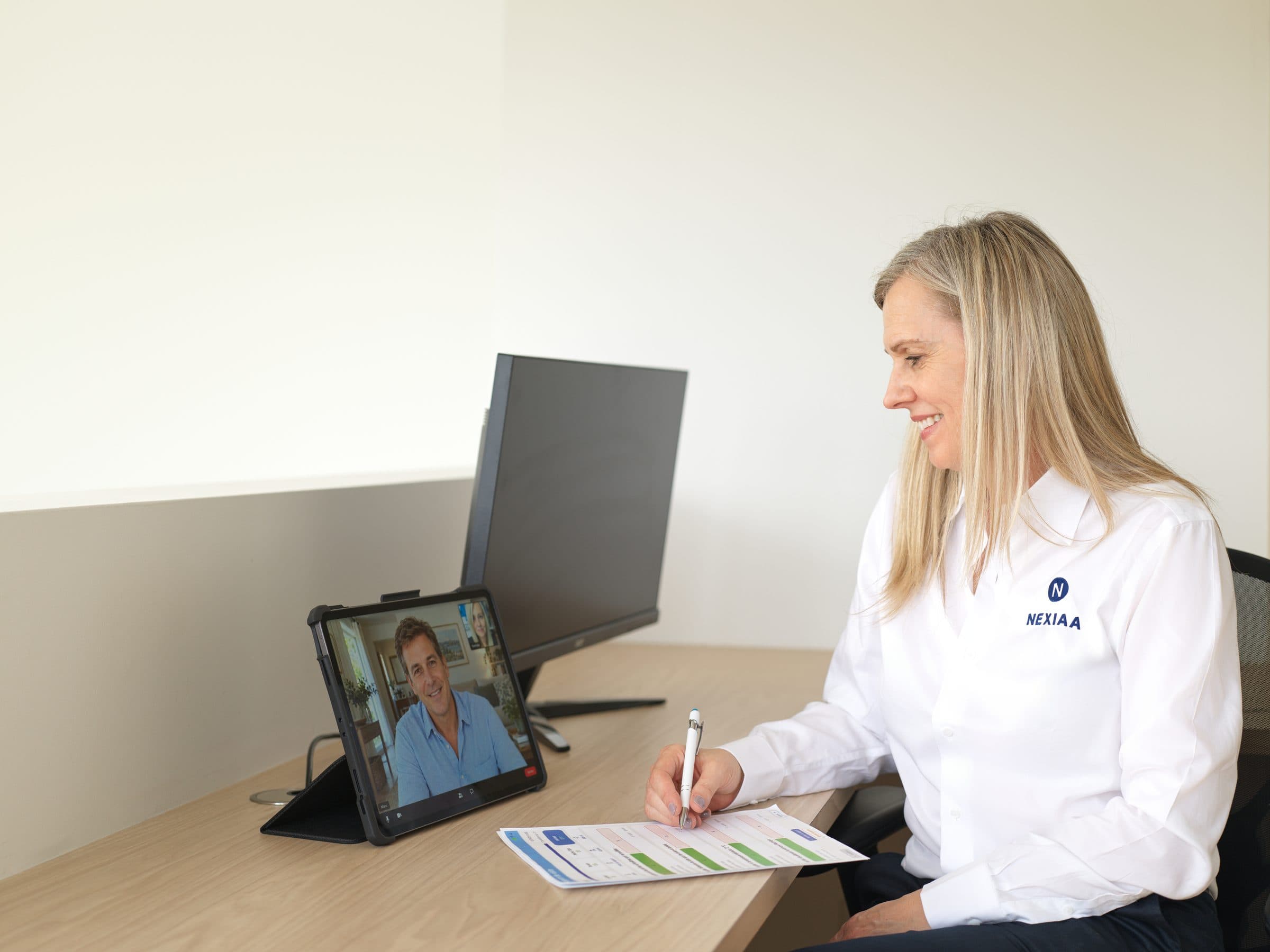 Nathalie en visioconférence avec un client à son bureau.